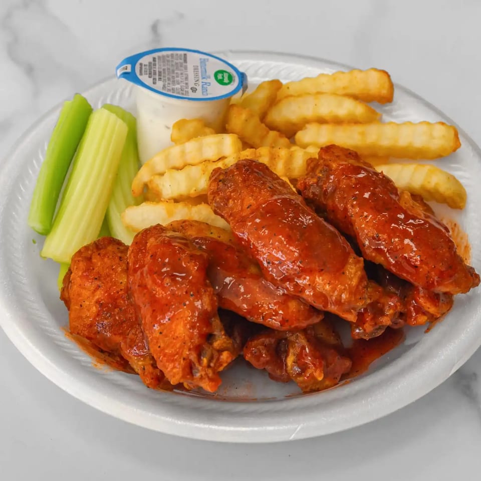 Aaron Wings & Hibachi's buffalo wings with crinkle-cut fries, celery sticks, and a ranch dipping cup.