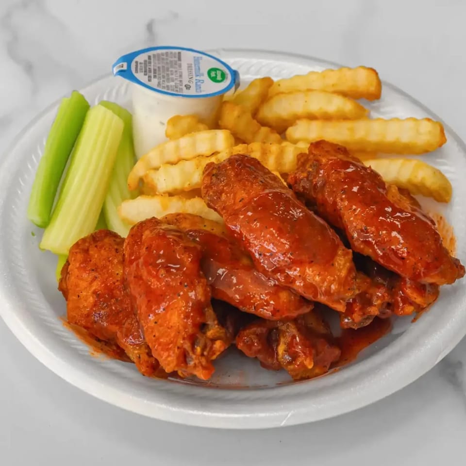 Aaron Wings & Hibachi's buffalo wings with crinkle-cut fries, celery sticks, and a side of ranch.
